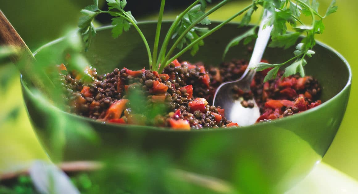 Salade de lentilles, poivrons rouges et persil dans un bol vert